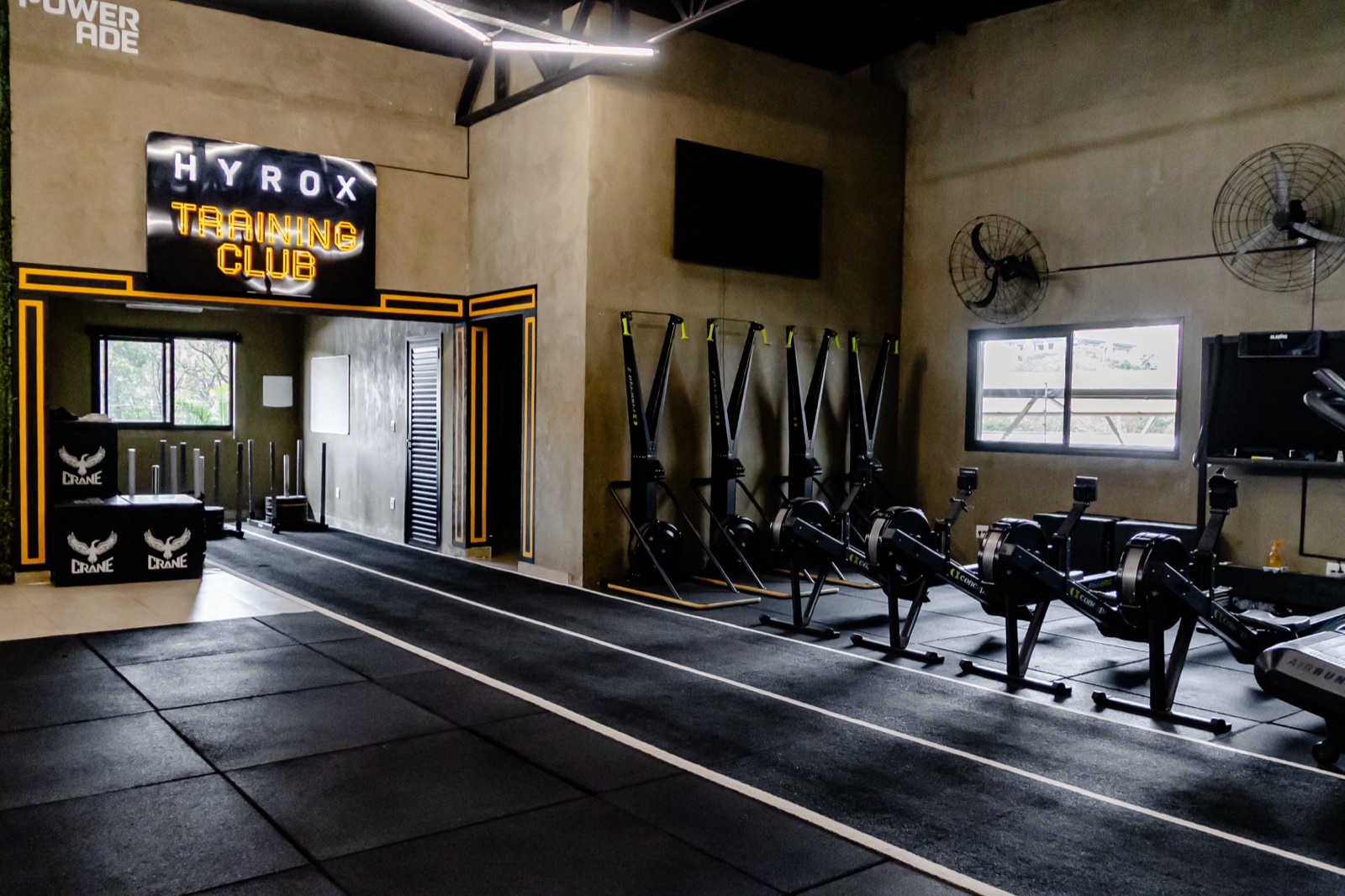 Espaço exclusivo do Hyrox Training Club na Crane, com letreiro neon 'Hyrox Training Club'